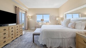 Une chambre à coucher avec un lit, une télévision, une commode et une fenêtre.