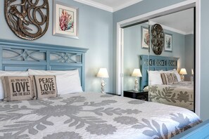 A bedroom with a bed, two nightstands, a dresser, and a large mirror. - Boardwalk F3 (Pensacola Beach)