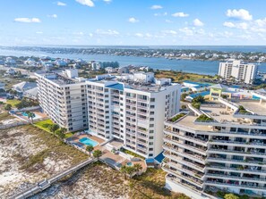 A high-rise hotel with multiple balconies, a pool, and a beach view. - Seaspray East 1023- Gulf Front (Pensacola)