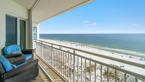 A balcony with wicker furniture and a view of the beach. - Seaspray East 1023- Gulf Front (Pensacola)