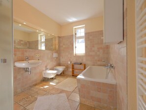 Une salle de bain équipée d’un lavabo, de toilettes, d’une baignoire et d’un miroir.