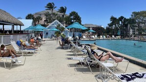 A poolside area with lounge chairs, umbrellas, and a pool. - 125.00 NIGHT! CONSTRUCTION SALE! NOW THRU SEPT! BEAUTIFUL JUPITER BAY 1BED 2BATH (Jupiter)