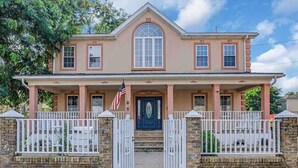 A two-story house with a central entrance, a front porch, and a stone wall. - Beach Mansion • 1 Block to Beach • Sleeps 16+ • Large Groups & Family Trips (Keansburg)