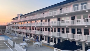 Un hôtel à plusieurs étages doté de balcons, d’une piscine et d’espaces de détente en plein air.