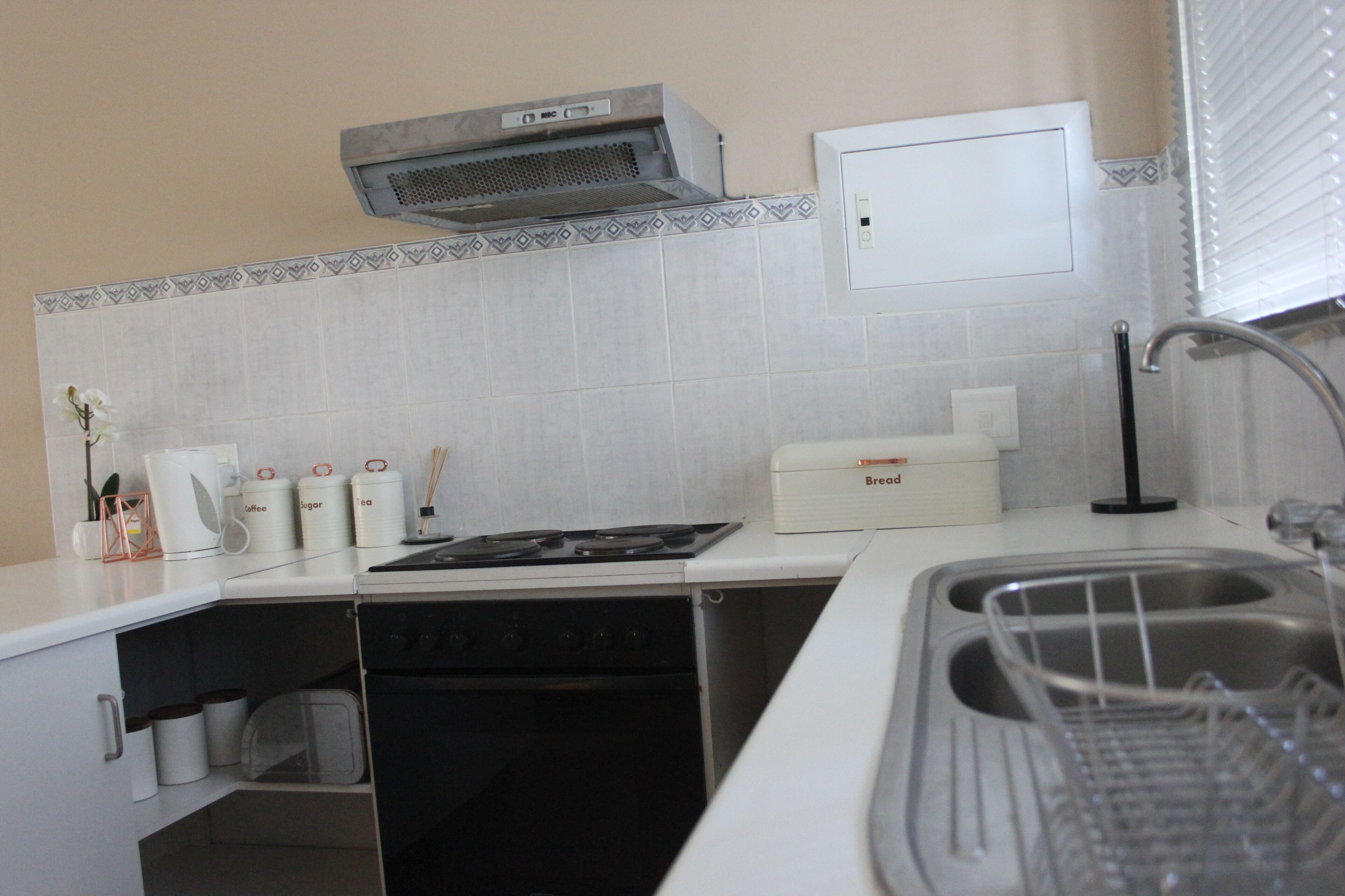 A compact kitchen with a stove, sink, and storage cabinets.