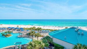 A resort with a swimming pool, beach area, and a view of the ocean.