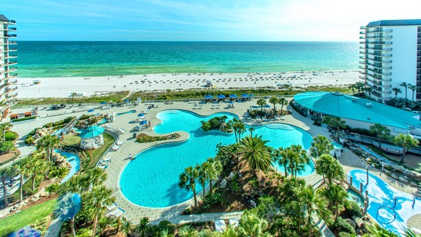Un resort con una piscina grande, playa y vista al océano.