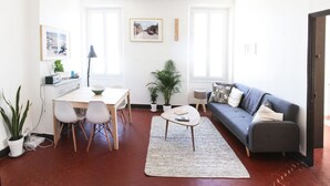 Una sala de estar moderna con comedor, un sofá gris y una mesa de centro.