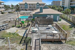 A resort with a pool, outdoor seating, and a wooden deck. - St. Martin Beachwalk Villas 412 (Destin)