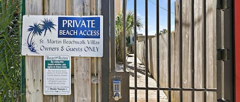 Una entrada cerrada a St. Martin Beachwalk Villas, con un cartel que indica acceso privado a la playa para propietarios e invitados.