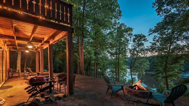 A covered outdoor area with a barbecue grill, seating, and a fire pit. - Lakefront Getaway, Private Dock, Porch, and Fishing! (Roxboro)