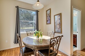 Un coin repas avec une table ronde, des chaises et une plante en pot.