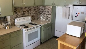 Une cuisine équipée d’une cuisinière, d’un réfrigérateur et de placards.