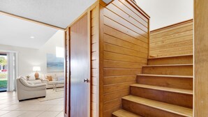 A modern interior with a wooden staircase, a sofa, and a lamp.