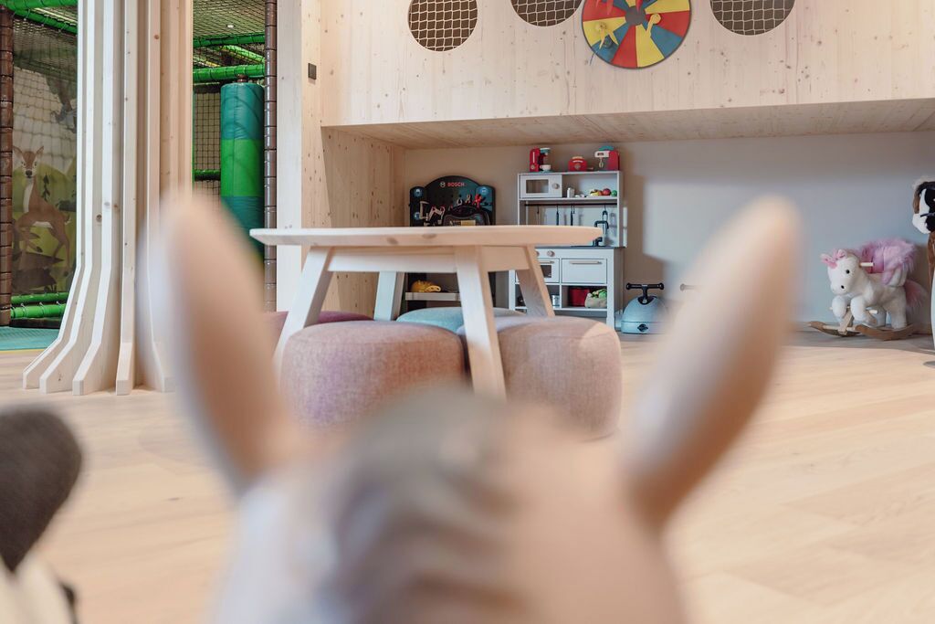 Une pièce avec un plancher en bois, une table et un ballon d’exercice vert.