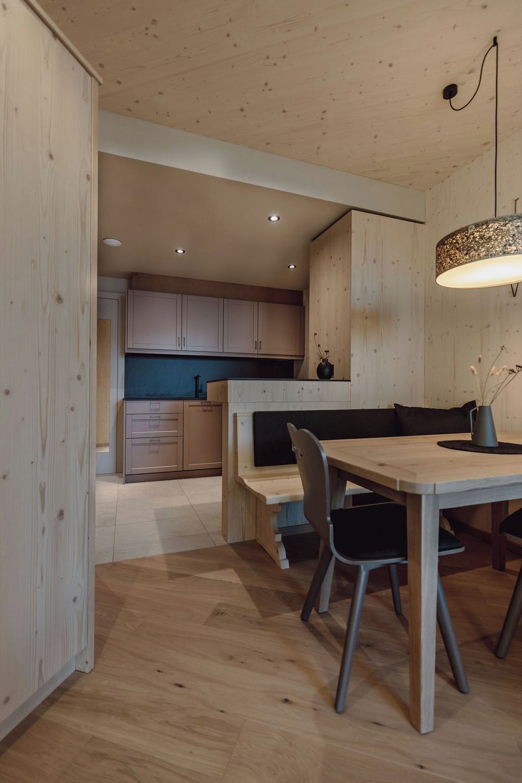 A modern kitchen with wooden cabinets and a dining area with a wooden table and chairs.