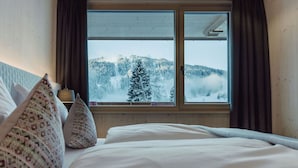 A bedroom with a large window, a bed, and two pillows. - Mariengut - Aparthotel Kramer (Wagrain)