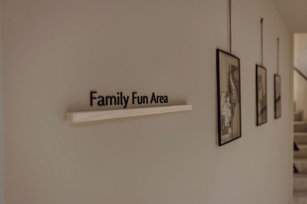 Un pasillo con un cartel que dice 'Family Fun Area' y una serie de cuadros en la pared.