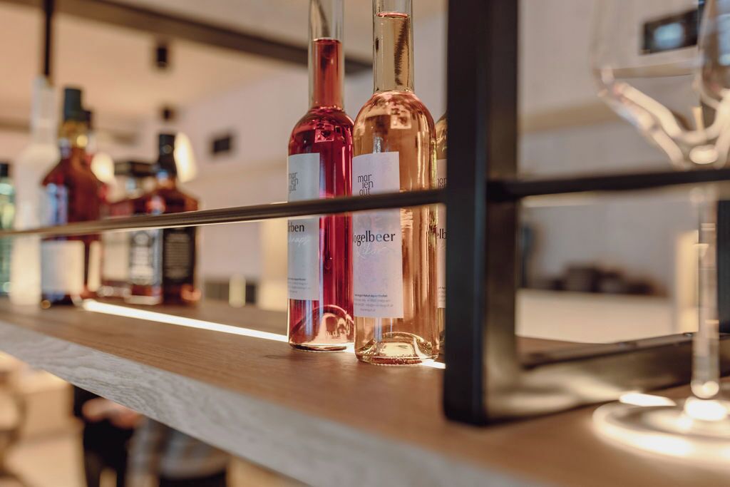 Eine Bar mit Flaschen Bier und Wein auf Regalen.