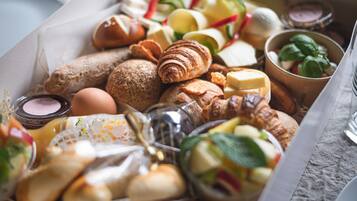 Un assortiment de viennoiseries et de fromages, présenté dans une boîte.