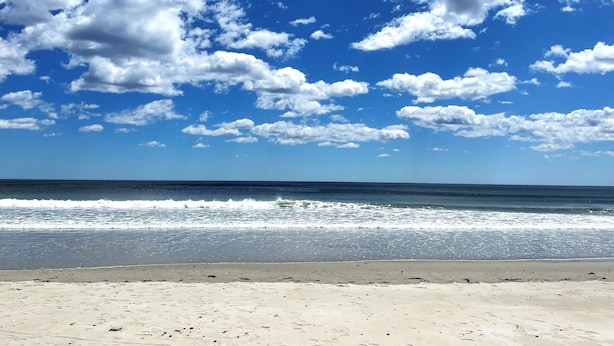 A beach with a clear sky and ocean waves.