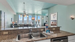A kitchen with granite countertops, stainless steel sinks, and a dishwasher.