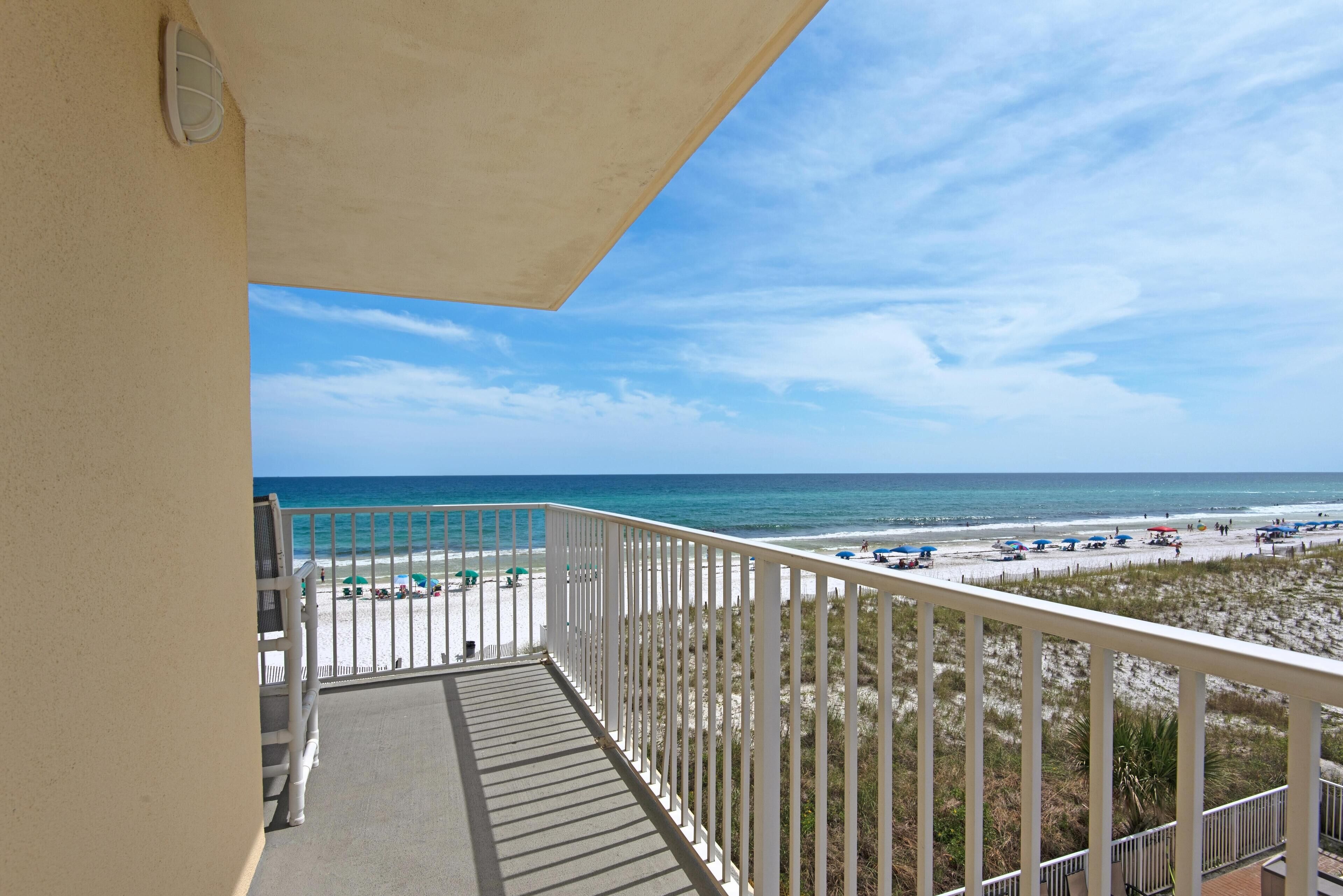 Un balcon avec vue sur la plage et l’océan.