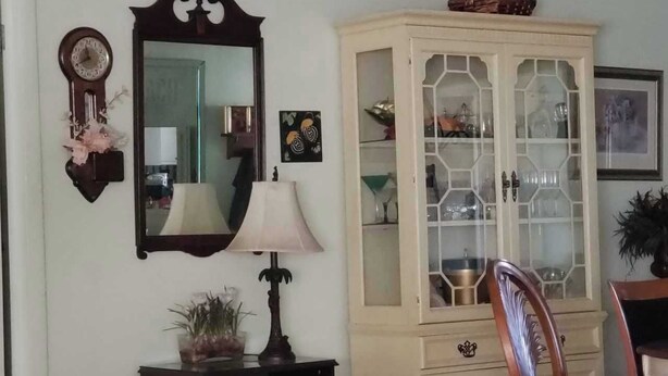A bedroom with a bed, a dresser, a mirror, a lamp, and a cabinet. - Cozy and beautiful Villa in trendy Fort Myers! Welcome to a home away form home! (Fort Myers)