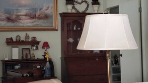 A room with a wooden cabinet, a lamp, and a painting on the wall. - Cozy and beautiful Villa in trendy Fort Myers! Welcome to a home away form home! (Fort Myers)