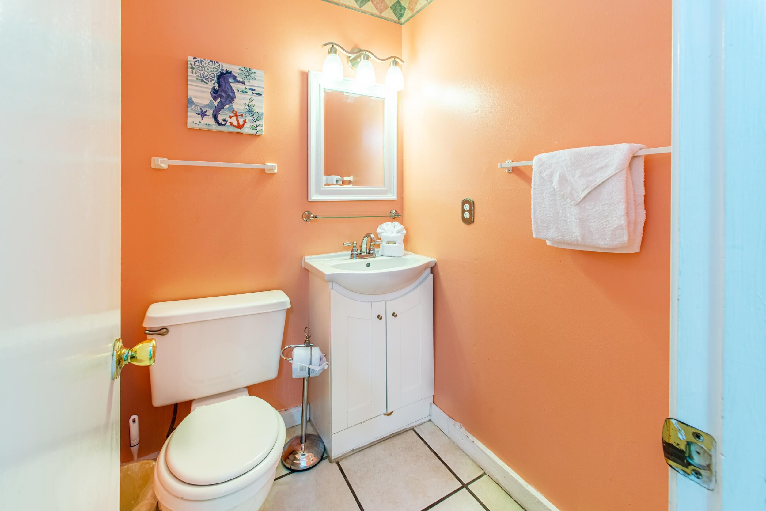 Une salle de bain avec des toilettes, un lavabo et un miroir.