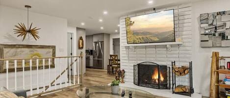 TV connectée, cheminée, livres, chaîne hi-fi