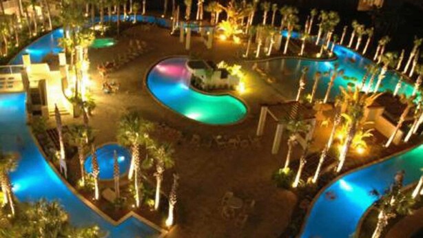 Ein Resort-Poolbereich mit mehreren Wasserspielen und Palmen.
