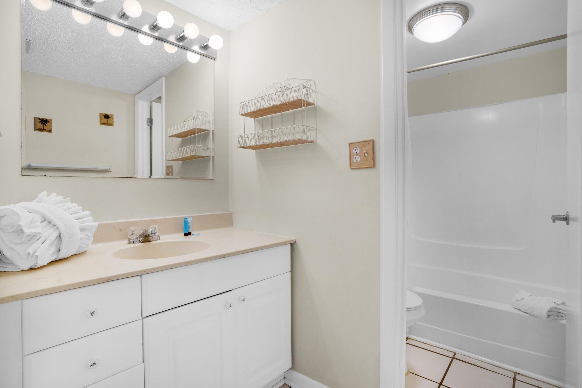 Une salle de bain avec un lavabo, un miroir et une douche.