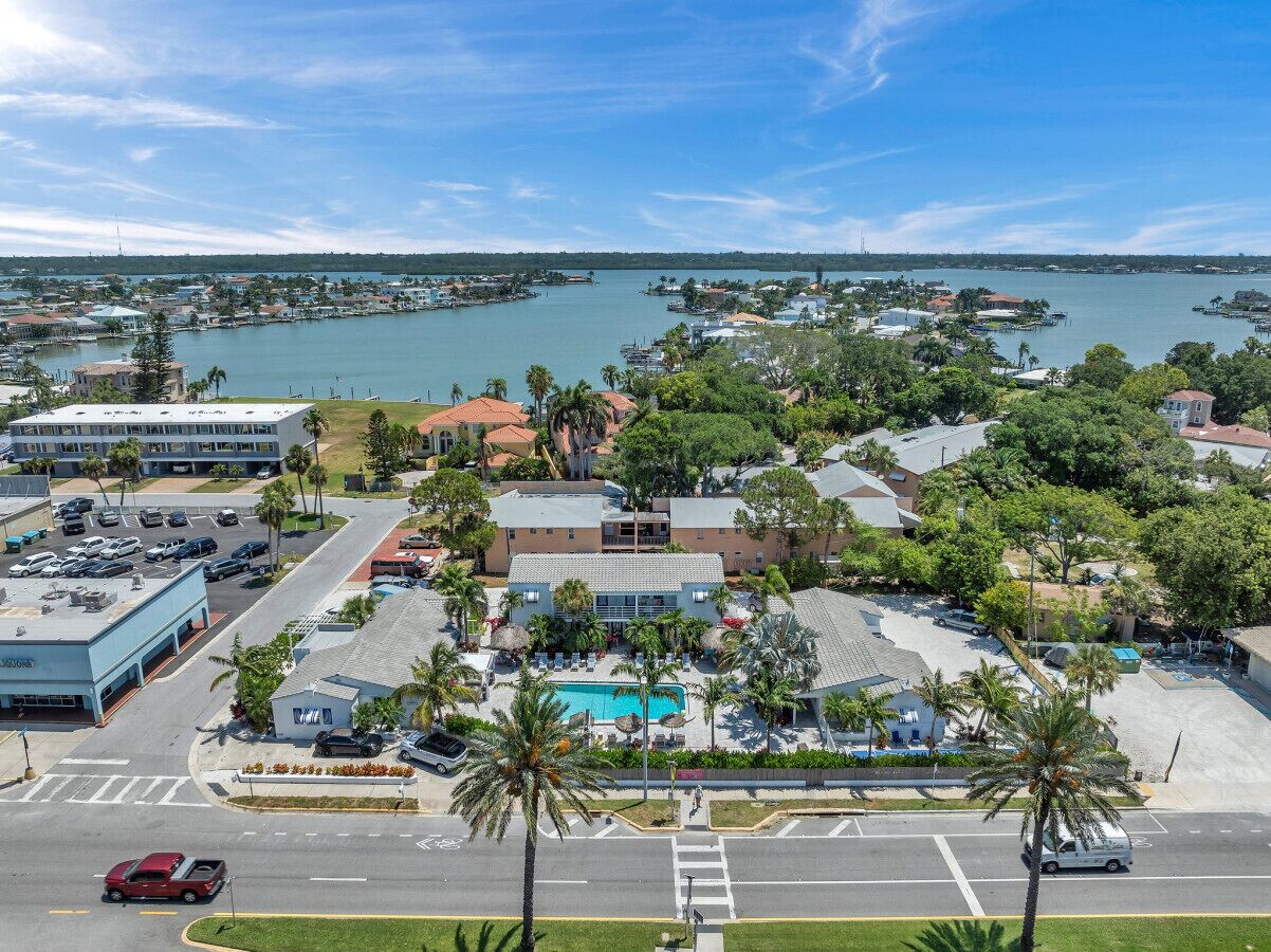 Vista aérea de una zona costera con un gran complejo de edificios, piscina y puerto deportivo.