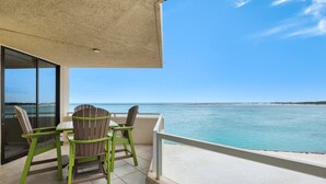 Ein Balkon mit Meerblick, einem Tisch und zwei Stühlen.