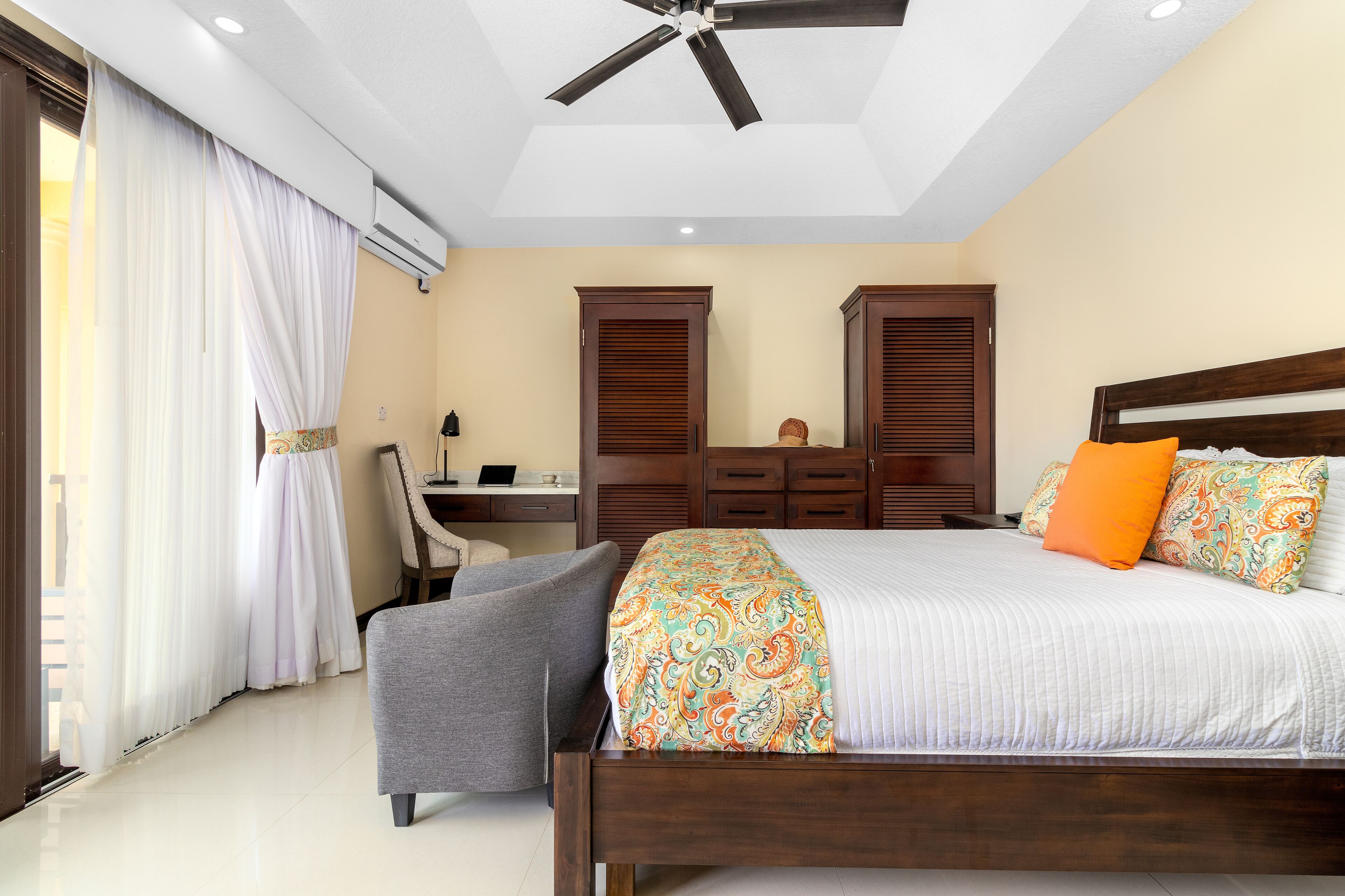 A bedroom with a bed, a desk, and a chair.