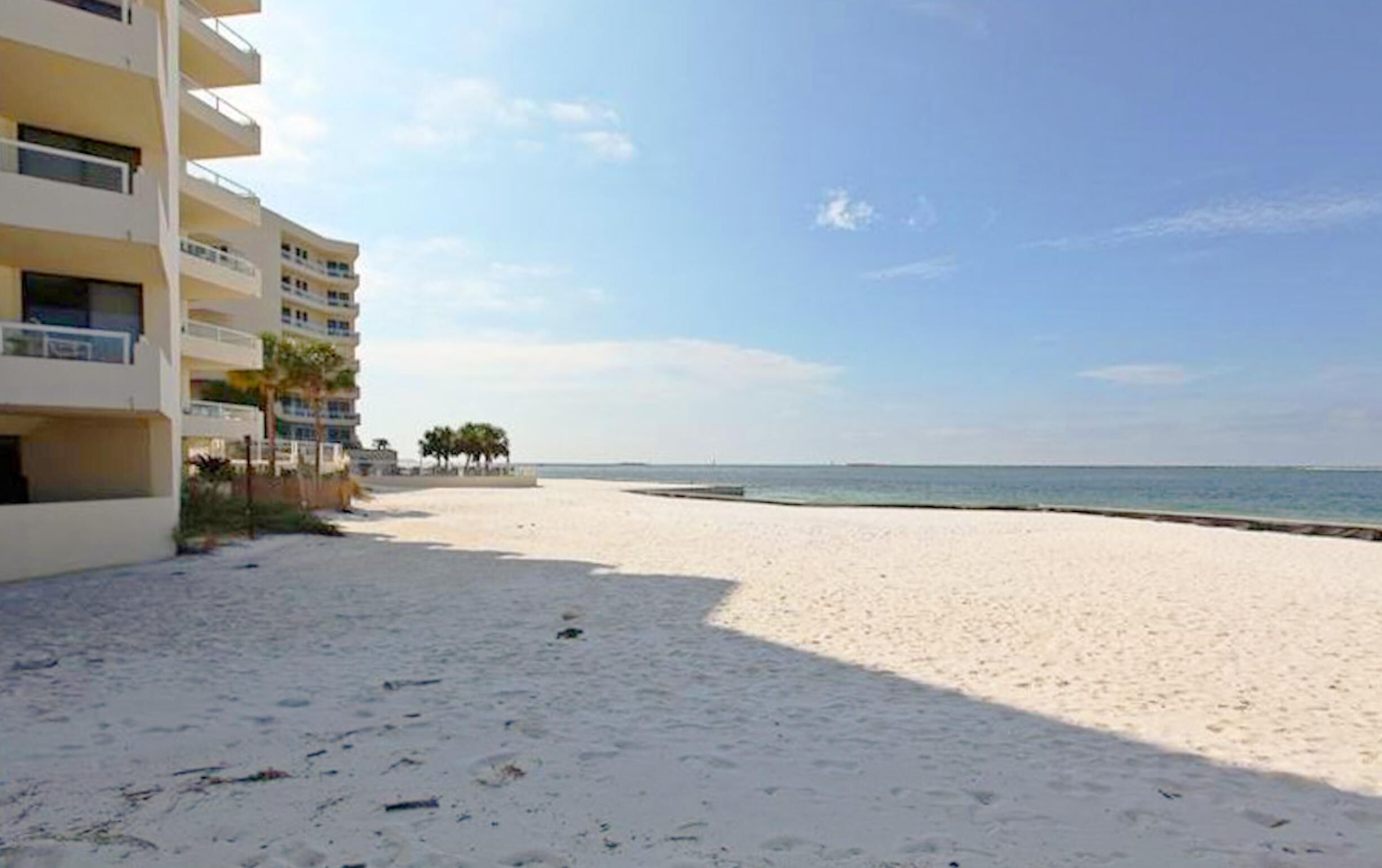 A beach with a building on the left.