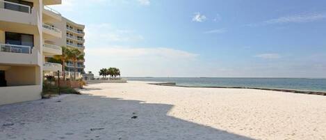 A beach with a building on the left.