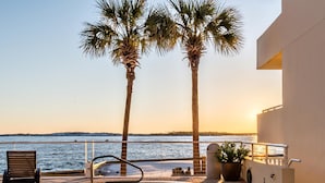 A spa area with a hot tub, palm trees, and a view of the sea. - East Pass 207 (Destin)