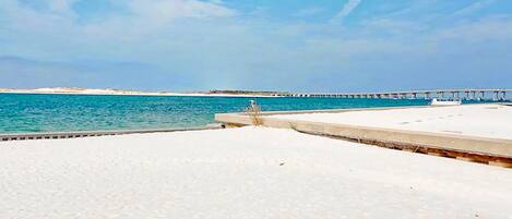 A beach with a pier extending into the water.
