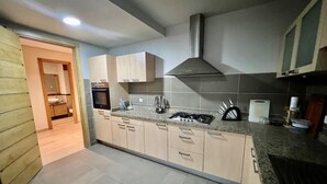 A modern kitchen with light wood cabinets, a stainless steel range hood, and a granite countertop. - Charming two bedroom apartment in the city center

 (Casablanca)