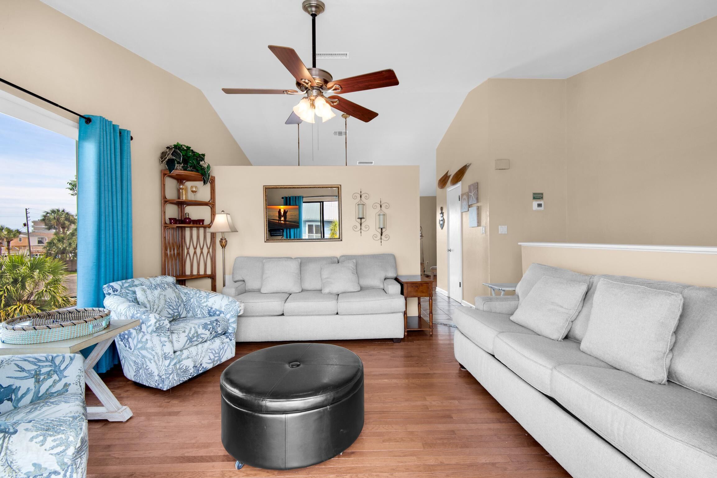 A living room with a ceiling fan, a sofa, a coffee table, and a side table.