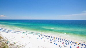A beach with rows of umbrellas and beach chairs, a clear blue sky, and calm sea. - Sundestin 1808 (Destin)