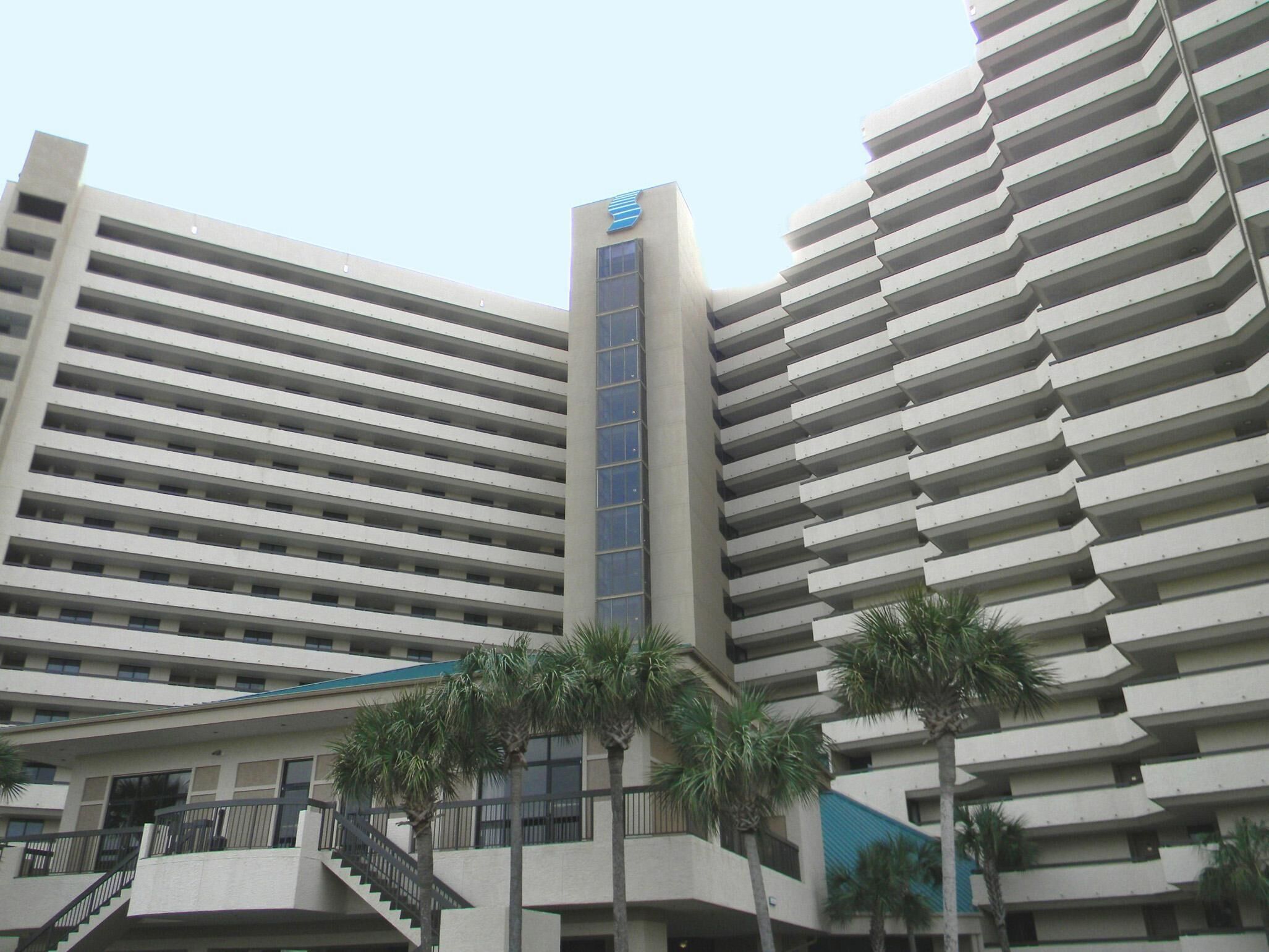 A high-rise hotel with multiple balconies and a central elevator shaft.