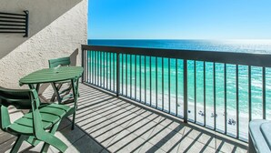 A balcony with a view of the ocean, a table, and two chairs. - Sundestin 1703 (Destin)