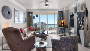 A modern living room with a sofa, armchair, glass coffee table, and a view of the outdoors. - St. Lucia 1103 (Destin)