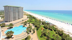 A resort with a large swimming pool, a beach with umbrellas, and a tall hotel building. - St. Lucia 1002 (Destin)