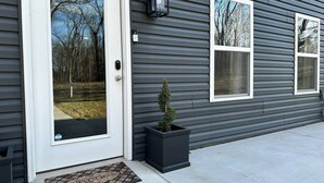 A house with a white front door, a mailbox, and a small potted plant.
