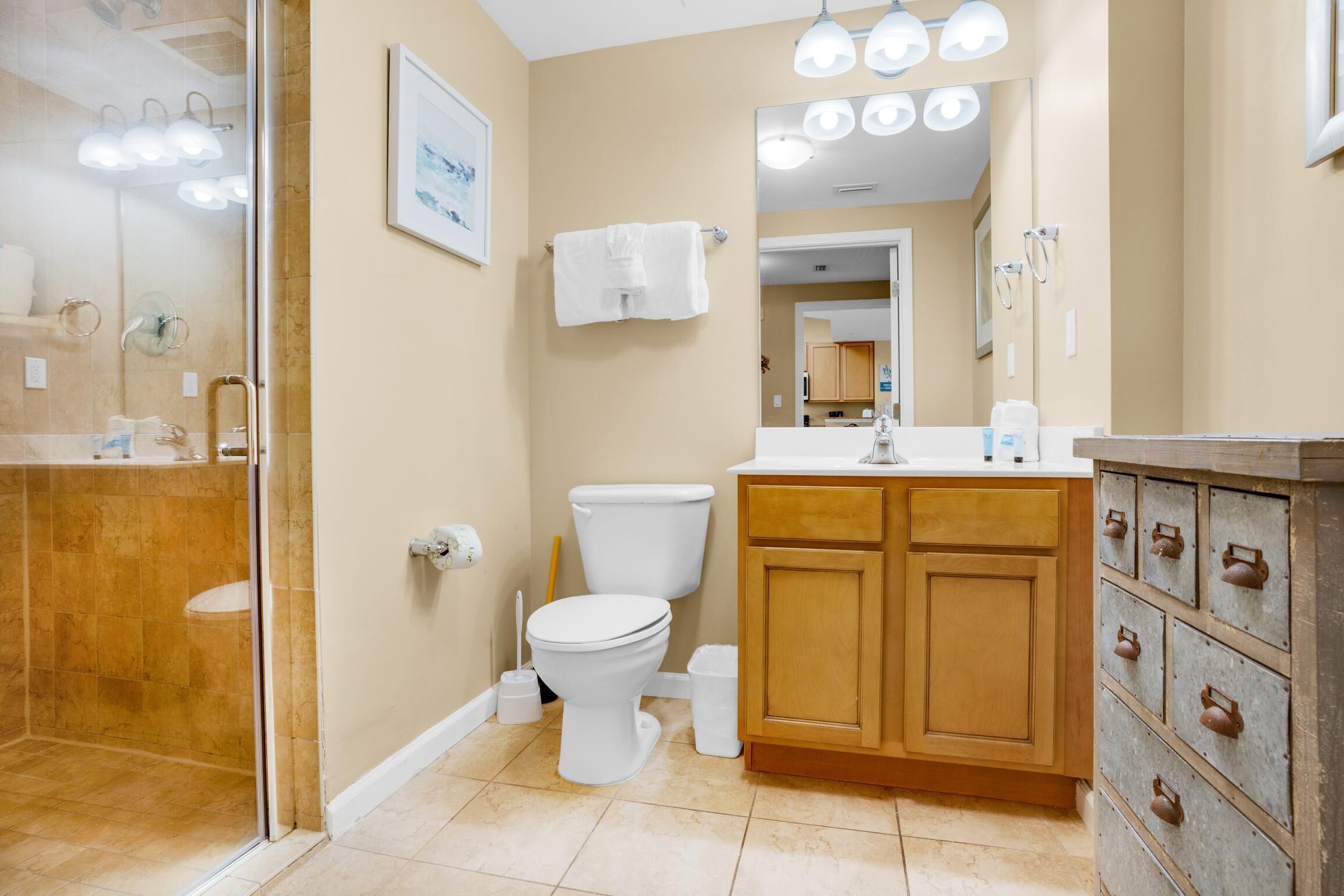 A bathroom with a toilet, sink, and shower area.