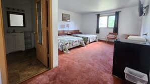 A room with two beds, a desk, a mirror, and a window. - The Hibernation Station (Sterling)